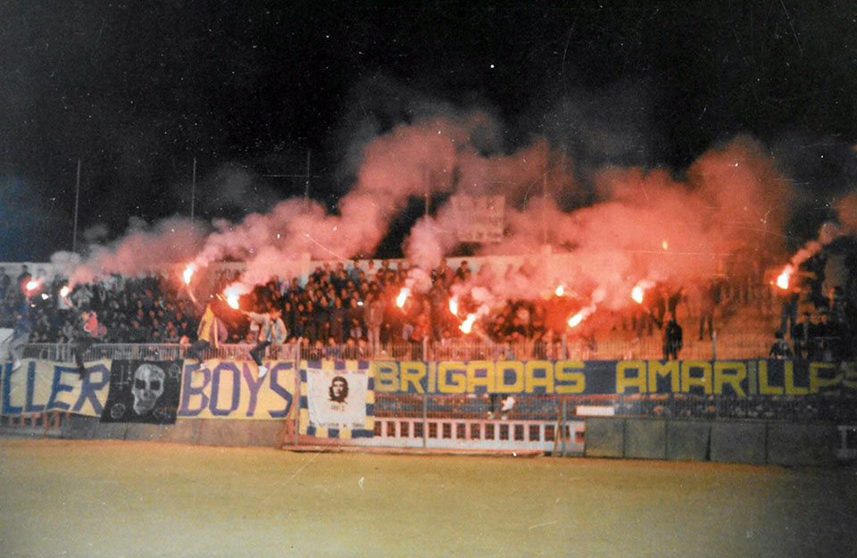 Grada de Brigadas Amarillas con bengalas y pancarta en el fondo del Cadiz