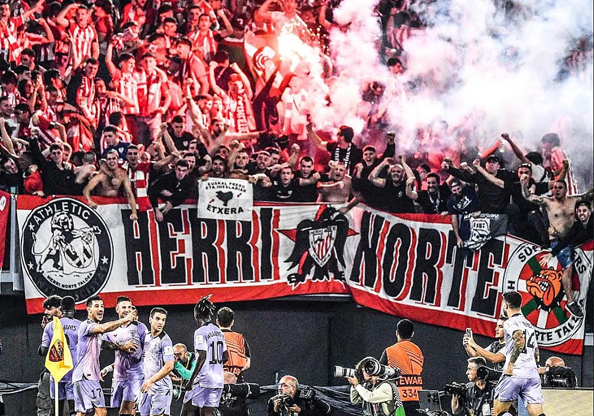 Herri Norte Taldea con bengalas, bufandas rojiblancas y gran pancarta en la curva