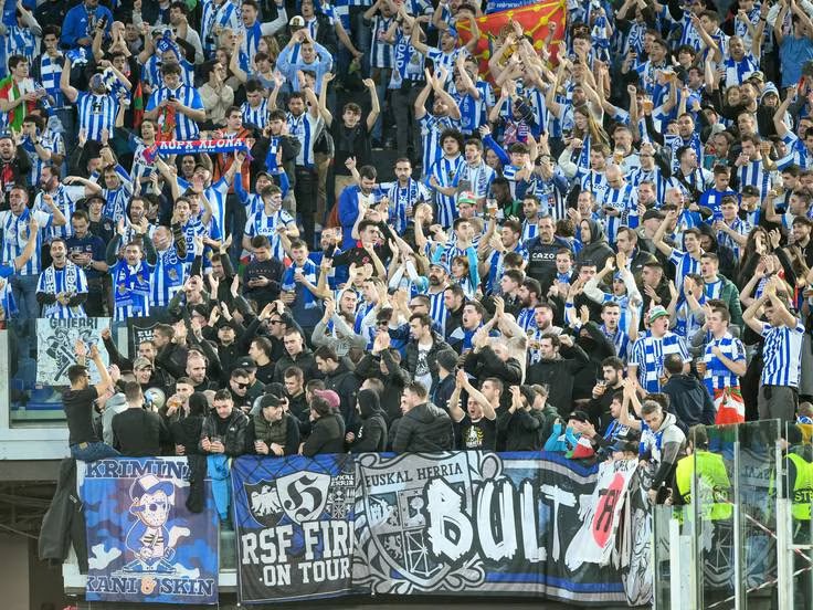 Aficionados animando en bloque con tonos azules y blancos