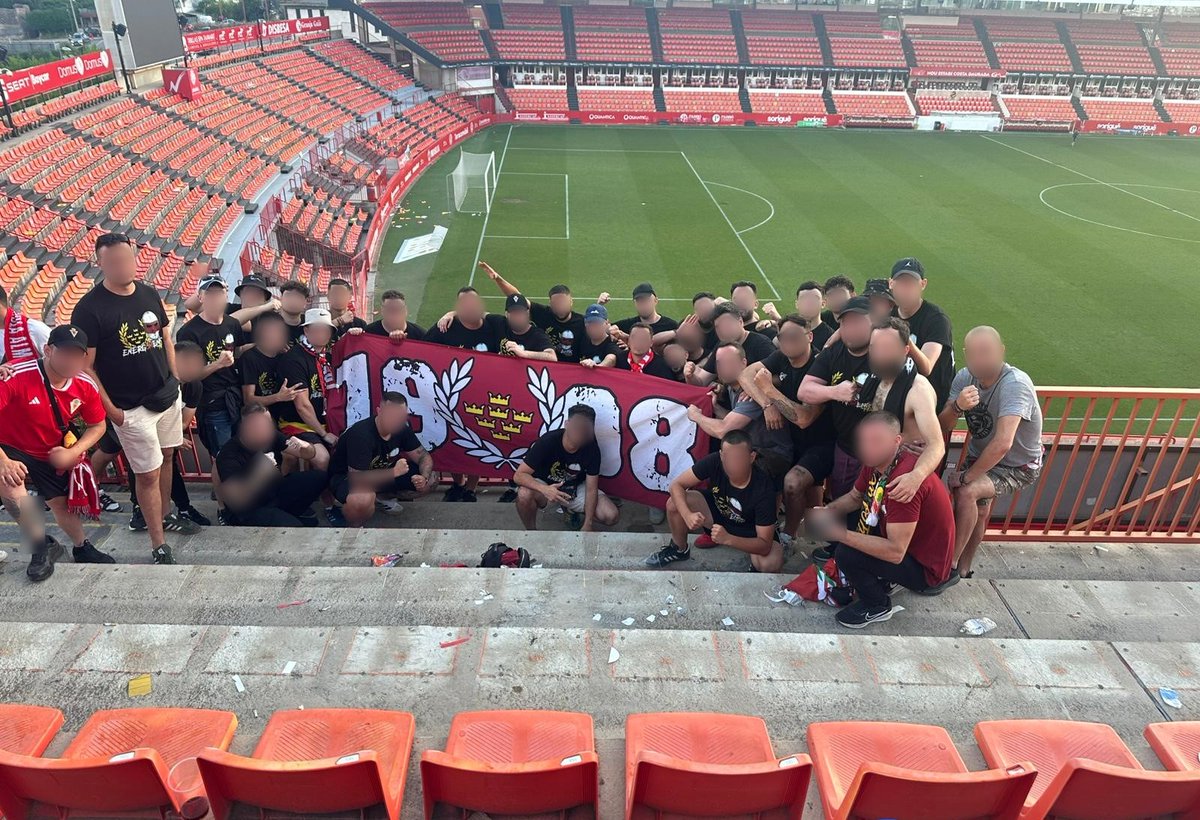 Ultras Murcia 1908 posando con una pancarta grana en la grada del Real Murcia